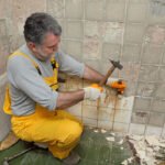Adult,Worker,Remove,,Demolish,Old,Tiles,In,A,Bathroom,With